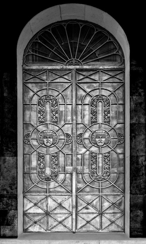 Immagine con porta, arco, portone, bianconero, grigio, nero, incisioni, metallo, geometrie, volti
